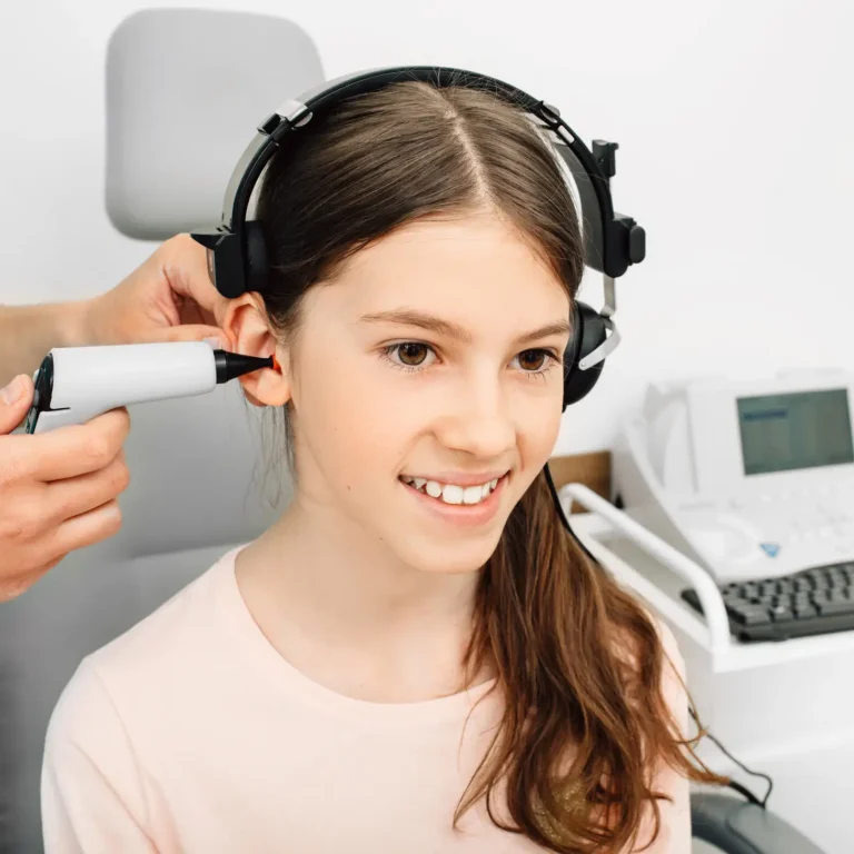 Audiologist is doing a hearing exam on a girl. Impedance audiometry. Methods for testing the middle ear in a child