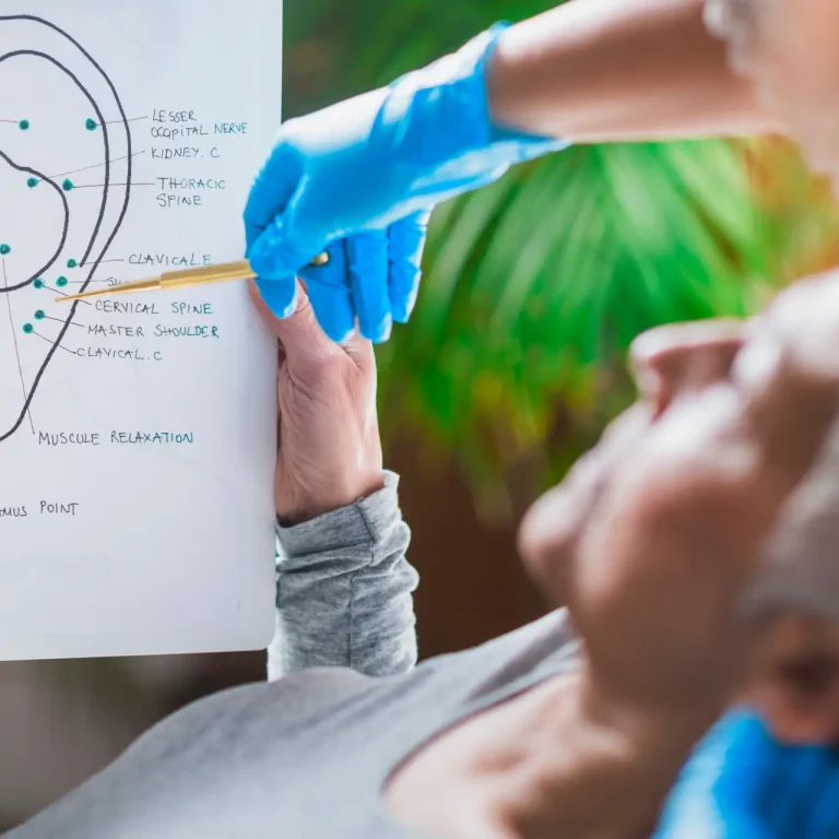 Patient learning about ear points in auriculotherapy treatment.
