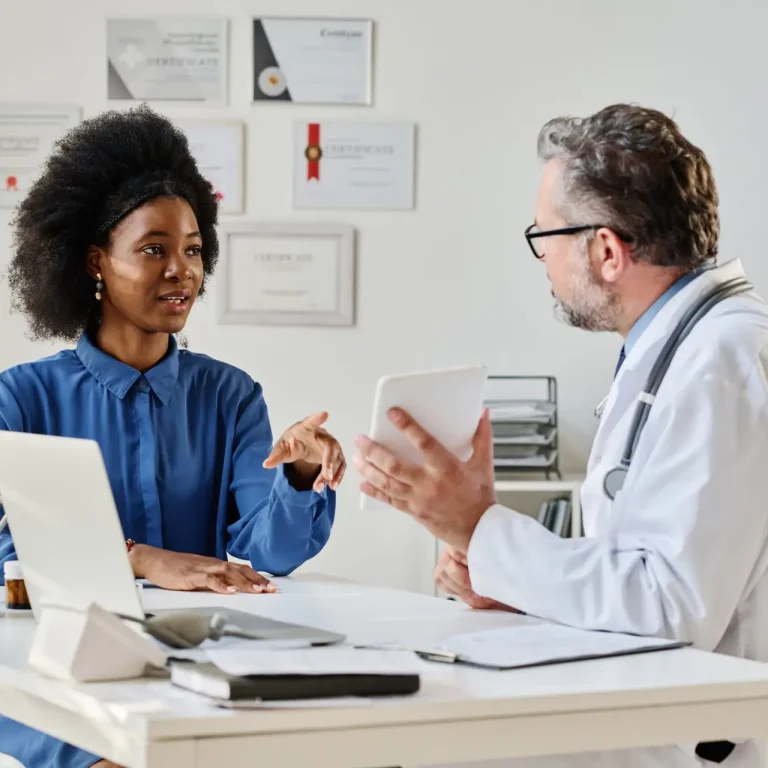 African young woman discussing treatment together with doctor at medical consultation
